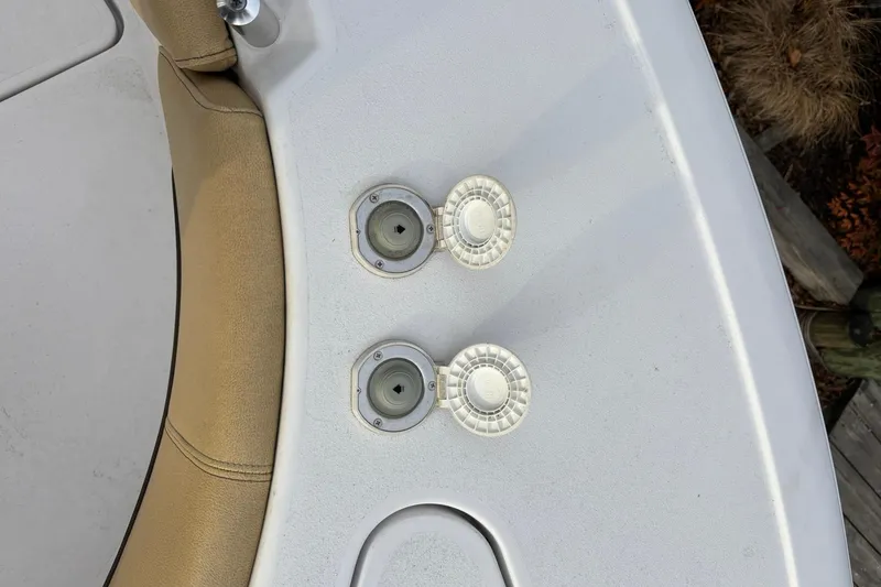 Slide: The Image of 2021 Sportsman Heritage 231 Center Console boat deck with cup holders and beige seating. - 24