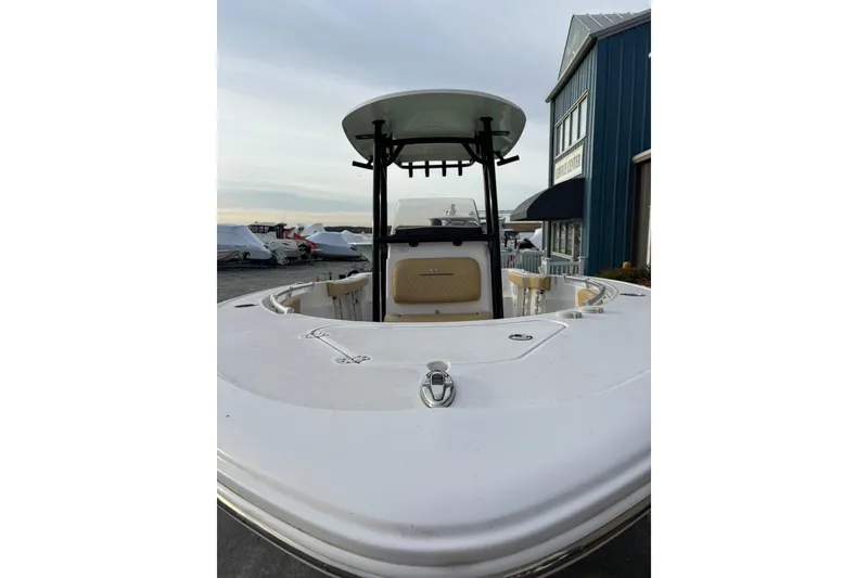Slide: The Image of 2021 Sportsman Heritage 231 Center Console boat docked near a blue building. - 3