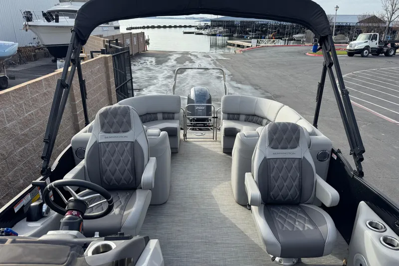Slide: The Image of 2022 Bennington R23 pontoon boat with luxurious seating and modern design at a marina. - 7
