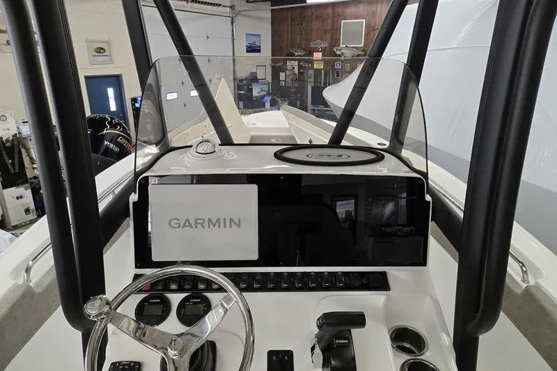 Slide: The Image of 2025 Sea Hunt Ultra 229 boat dashboard with Garmin navigation system in a showroom. - 16