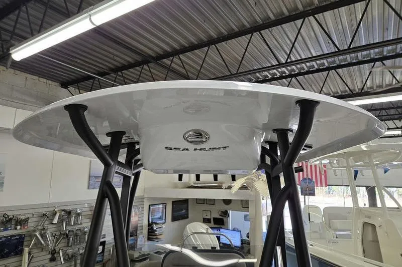Slide: The Image of 2025 Sea Hunt Ultra 229 boat in showroom, featuring sleek T-top design. - 3