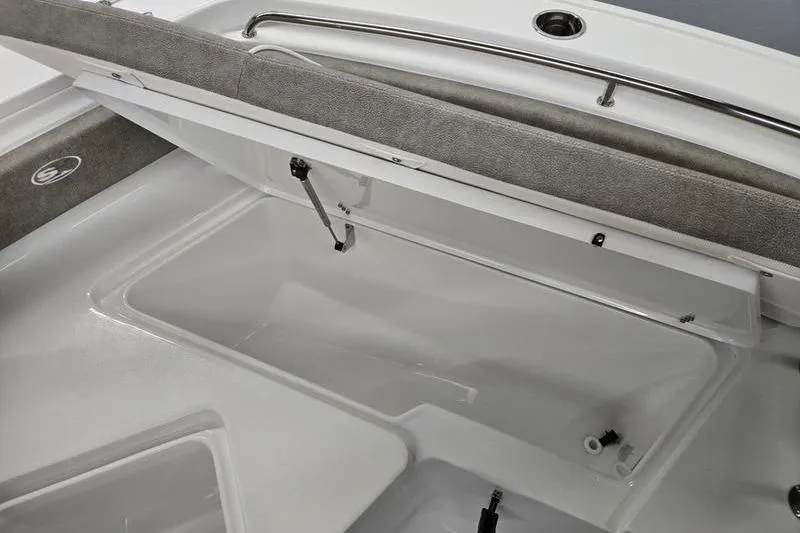 Slide: The Image of 2025 Sea Hunt Ultra 229 boat storage compartment with open lid and cushioned seating. - 9