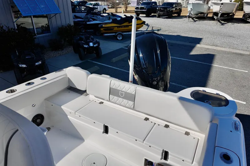 Slide: The Image of 2026 Sea Fox 248 Side Console boat interior with seating and motor, parked outdoors. - 13