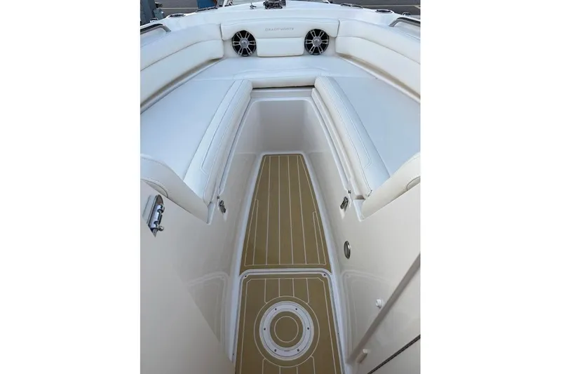 Slide: The Image of 2022 Grady-White Freedom 235 boat interior with cushioned seating and teak-style flooring. - 13