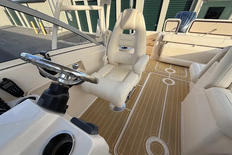 Slide: The Image of 2022 Grady-White Freedom 235 boat interior with luxurious seating and modern steering wheel. - 18