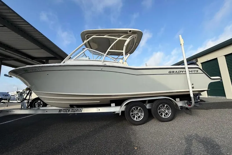 Slide: The Image of 2022 Grady-White Freedom 235 boat on trailer, parked outdoors. - 2