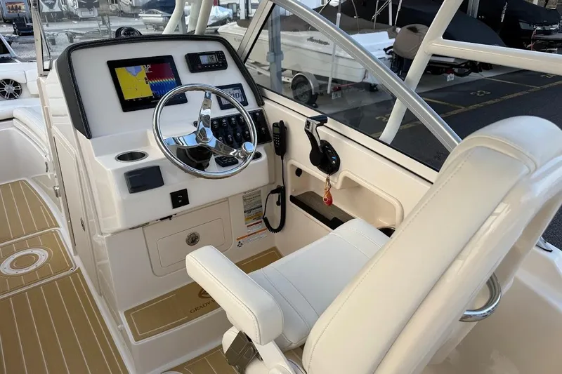 Slide: The Image of 2022 Grady-White Freedom 235 boat cockpit with steering wheel and navigation display. - 21