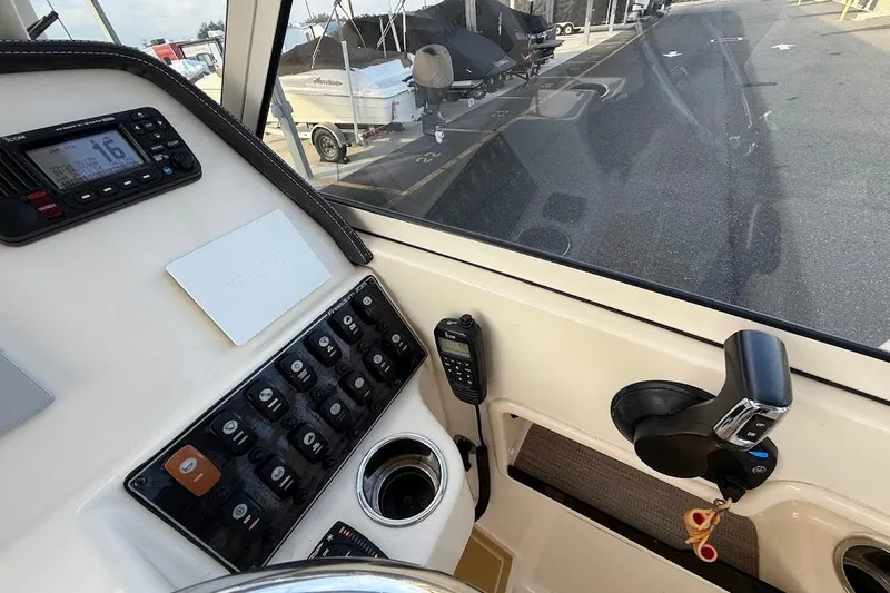 Slide: The Image of 2022 Grady-White Freedom 235 boat dashboard with controls and radio equipment. - 23