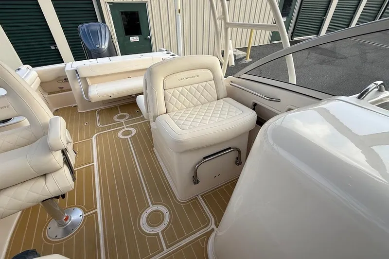 Slide: The Image of 2022 Grady-White Freedom 235 boat interior with beige seating and wood-patterned flooring. - 25