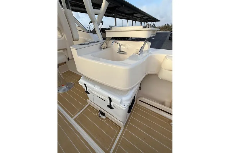 Slide: The Image of 2022 Grady-White Freedom 235 boat interior with sink and cooler on deck. - 31
