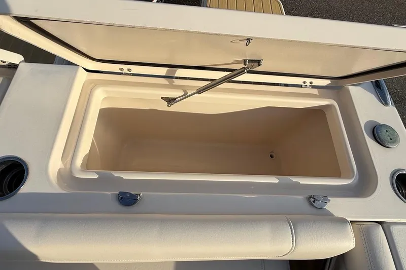 Slide: The Image of Open storage compartment on 2022 Grady-White Freedom 235 boat, featuring cup holders. - 38