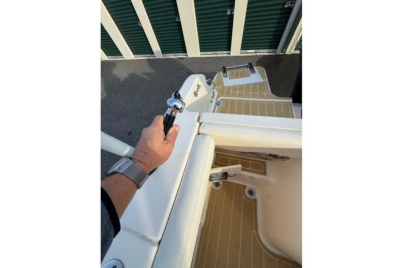 Slide: The Image of 2022 Grady-White Freedom 235 boat interior with hand on railing, near storage units. - 40