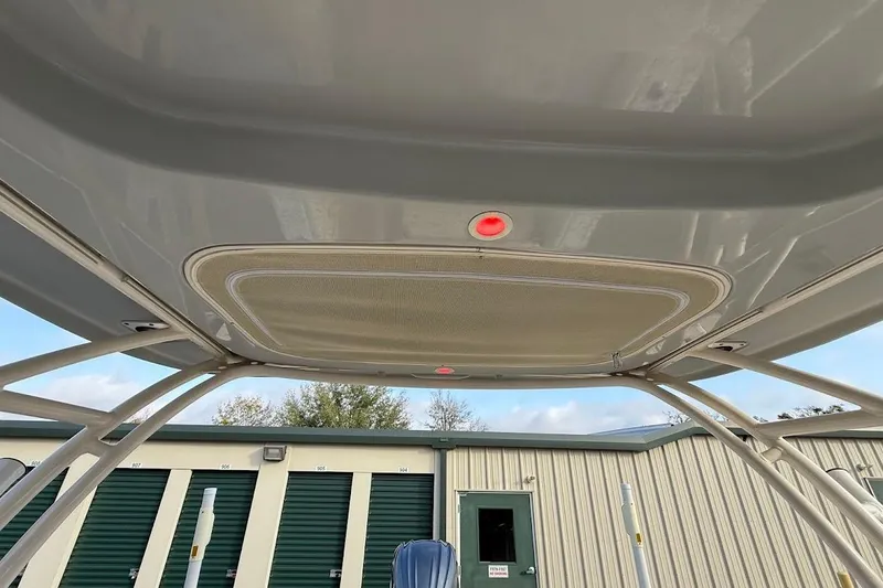 Slide: The Image of 2022 Grady-White Freedom 235 boat canopy with red light, storage units in background. - 43