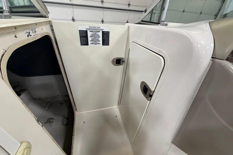 Slide: The Image of 2006 Sea Ray 200 Sundeck interior with storage compartment and cabin door. - 12