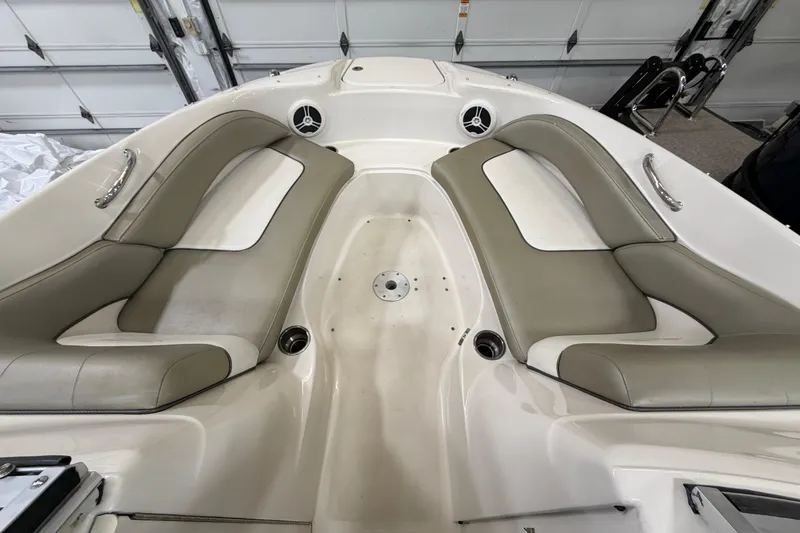 Slide: The Image of 2006 Sea Ray 200 Sundeck interior with beige seating and cup holders. - 13