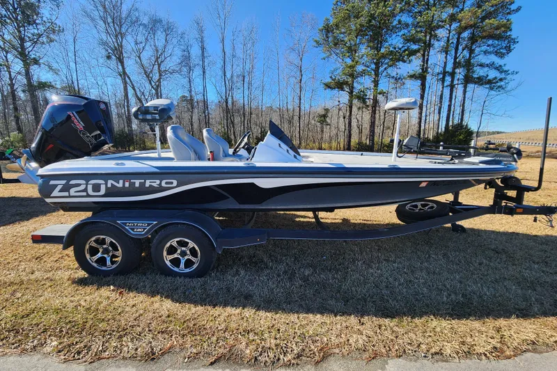 The Image of 2023 Nitro Z20 boat on trailer, parked on grass with trees in background. - 0