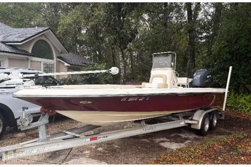 The Image of 2006 ShearWater Z2200 boat on trailer, parked near a house in a wooded area. - 1