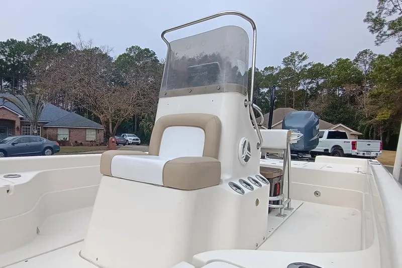 Slide: The Image of 2006 ShearWater Z2200 boat with center console and seating, parked in a residential area. - 16