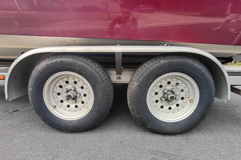 Slide: The Image of Trailer wheels of a 2006 ShearWater Z2200 boat on asphalt road. - 18