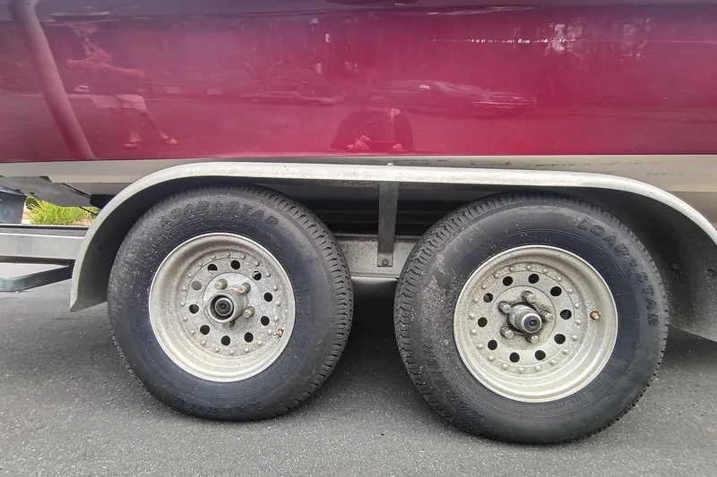 Slide: The Image of Trailer wheels of a 2006 ShearWater Z2200 boat on pavement. - 19
