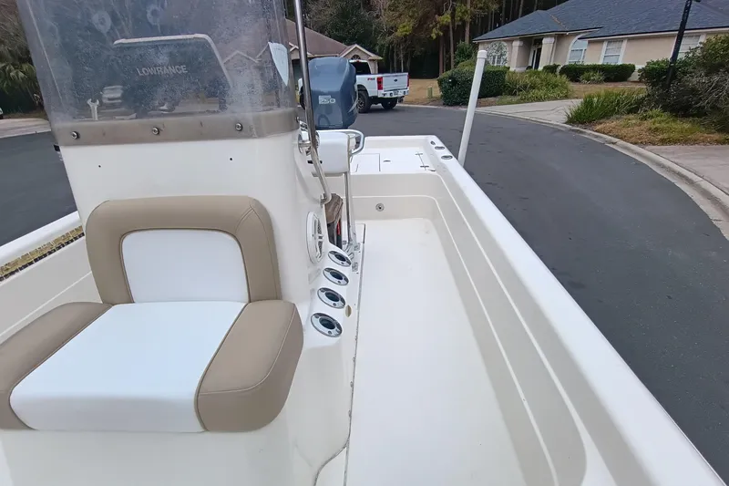 Slide: The Image of 2006 ShearWater Z2200 boat interior with seating and console, parked in residential area. - 45