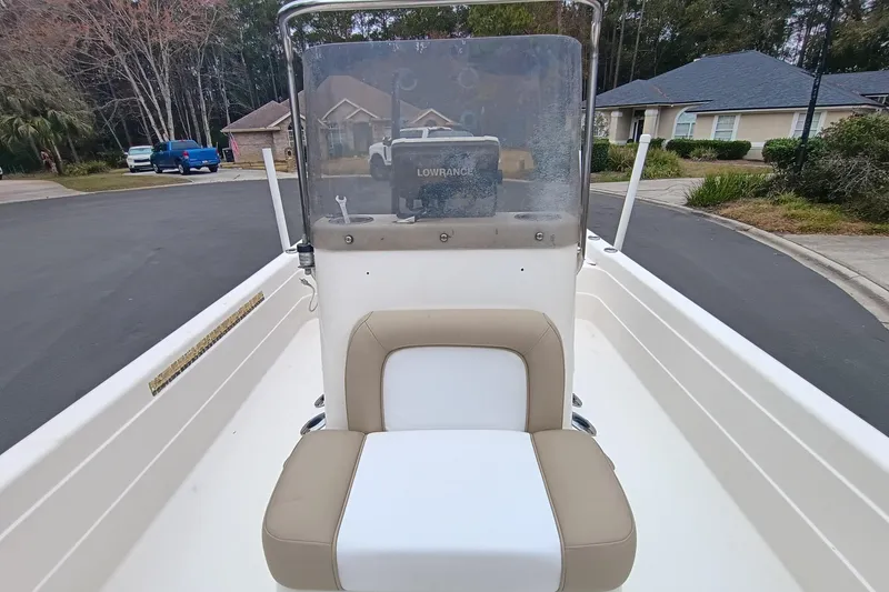 Slide: The Image of 2006 ShearWater Z2200 boat interior with beige seating and windshield in a residential area. - 49