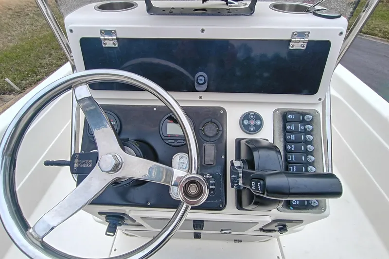 Slide: The Image of 2006 ShearWater Z2200 boat dashboard with steering wheel and control panel. - 54