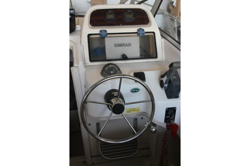 Slide: The Image of Helm of 2000 Grady-White Adventure 208 boat with steering wheel and Simrad display. - 3