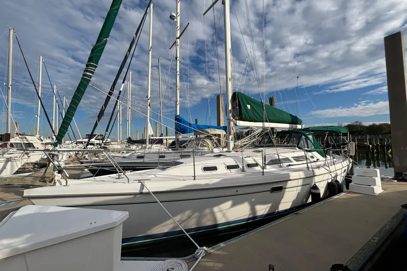 The Image of 1999 Catalina 380 sailboat docked at marina under partly cloudy sky. - 0