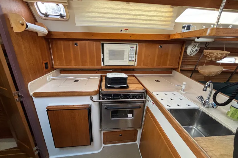 Slide: The Image of Interior of a 1999 Catalina 380 sailboat with cozy seating and wooden accents. - 11