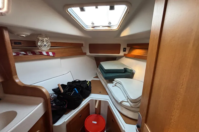 Slide: The Image of 1999 Catalina 380 yacht kitchen with wood cabinetry, stove, microwave, and sink. - 19
