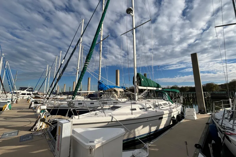 Slide: The Image of Sailboats docked at marina under cloudy sky, featuring a 1999 Catalina 380. - 2