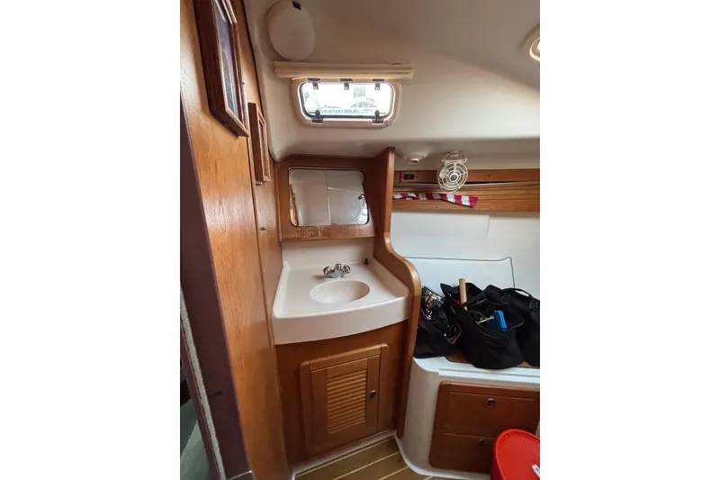 Slide: The Image of 1999 Catalina 380 yacht kitchen with stove, sink, and wooden cabinetry. - 20