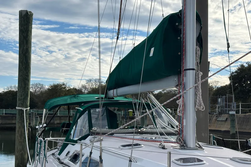 Slide: The Image of Catalina 380 sailboat from 1999 docked, featuring green sail cover and clear sky. - 3