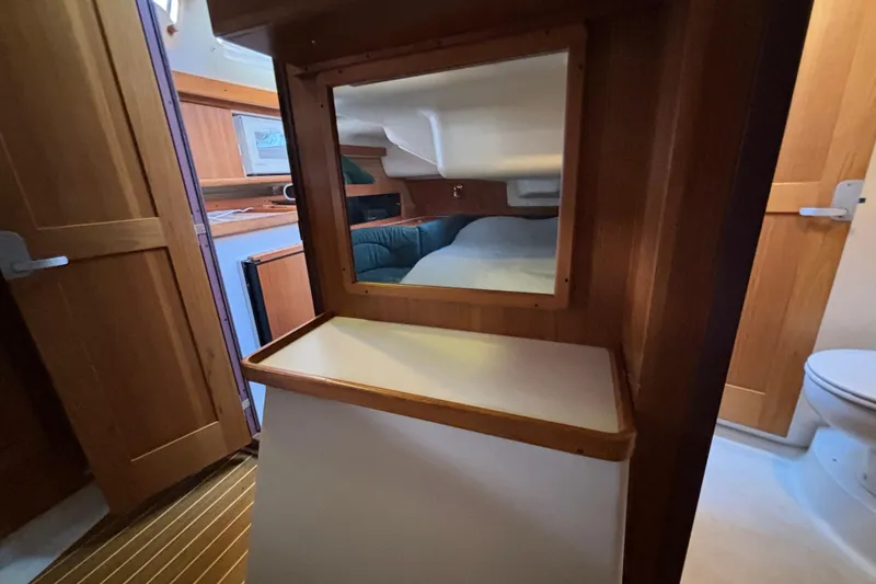 Slide: The Image of Interior of a 1999 Catalina 380 sailboat featuring wood paneling and a cozy cabin space. - 34