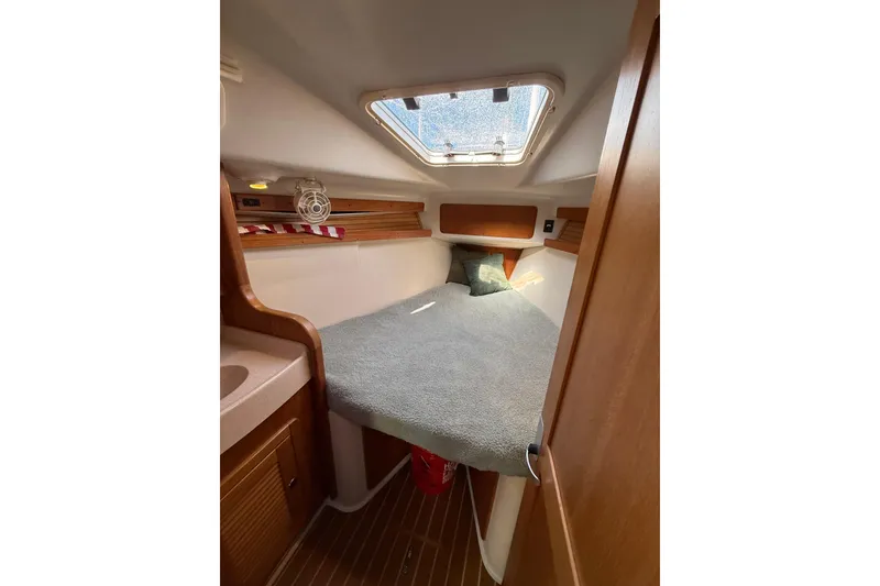 Slide: The Image of Cozy cabin interior of a 1999 Catalina 380 sailboat with a skylight and wooden accents. - 42