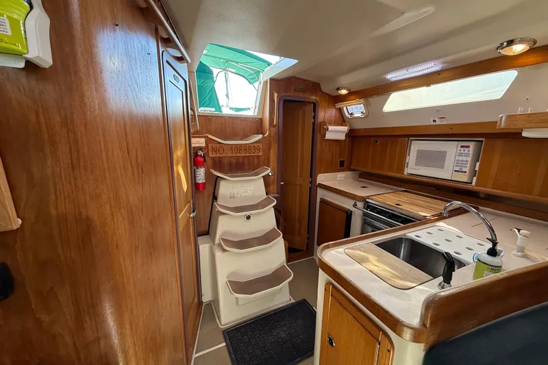 Slide: The Image of Interior of a 1999 Catalina 380 sailboat with kitchen and wooden cabinetry. - 43