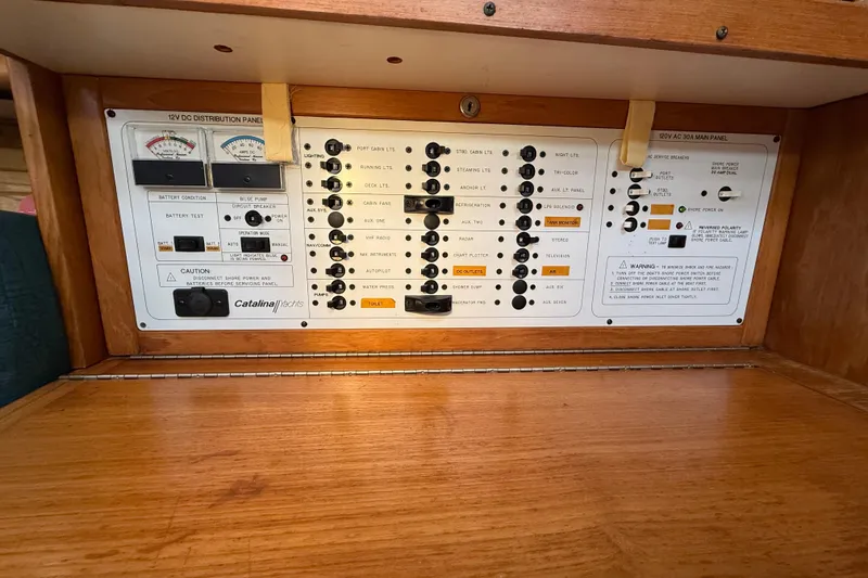 Slide: The Image of Control panel of a 1999 Catalina 380 yacht, featuring various switches and gauges. - 46