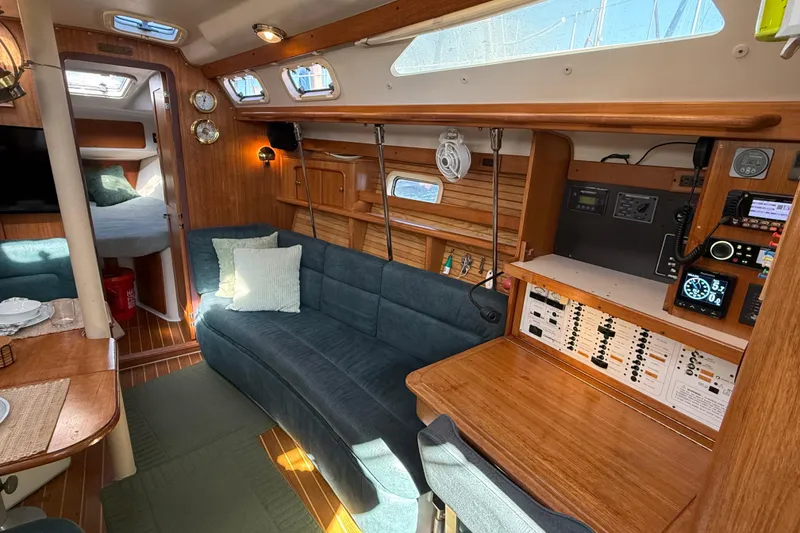 Slide: The Image of Interior of a 1999 Catalina 380 sailboat with cozy seating and navigation equipment. - 48