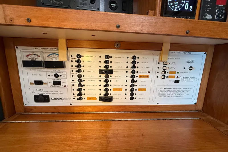 Slide: The Image of Electrical control panel of a 1999 Catalina 380 yacht with various switches and gauges. - 53