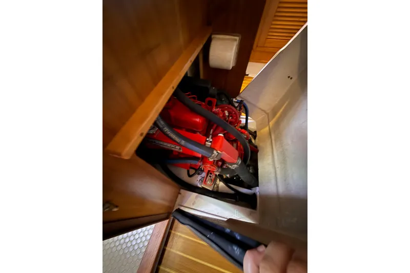 Slide: The Image of Engine compartment of a 1999 Catalina 380 sailboat, featuring red engine components. - 55
