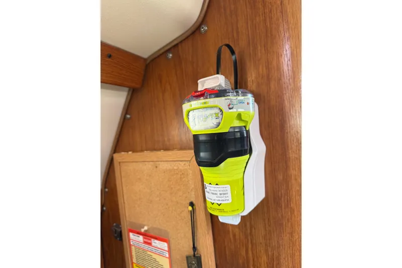Slide: The Image of Emergency beacon mounted on a wooden panel inside a 1999 Catalina 380 sailboat. - 57