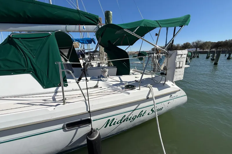 Slide: The Image of 1999 Catalina 380 sailboat named "Midnight Sun" docked with green canopy. - 61