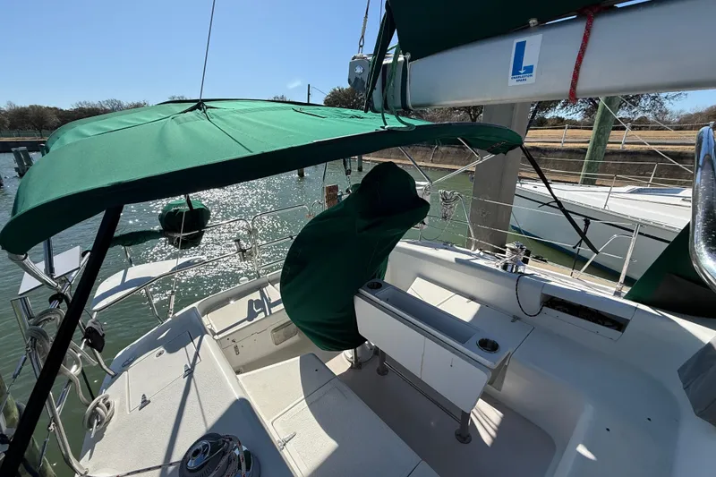 Slide: The Image of Sailboat cockpit of 1999 Catalina 380 with green canopy, docked in sunny marina. - 64