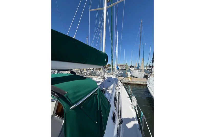Slide: The Image of Sailboat Catalina 380, 1999 model, docked in a marina under clear blue skies. - 65