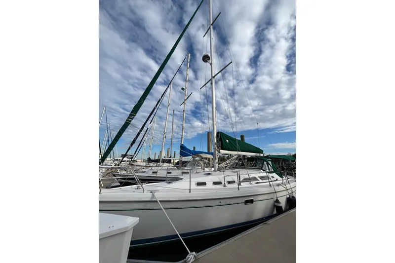 Slide: The Image of Sailboat Catalina 380, 1999 model, docked under a partly cloudy sky. - 68