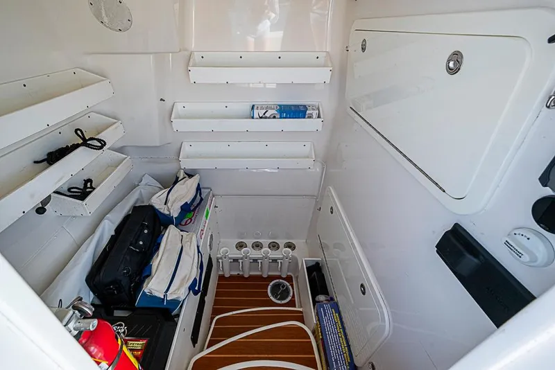 Slide: The Image of 2011 Yellowfin 39 Offshore boat interior storage area with shelves and equipment. - 27