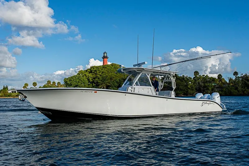 Slide: The Image of 2011 Yellowfin 39 Offshore boat cruising near a scenic lighthouse. - 36