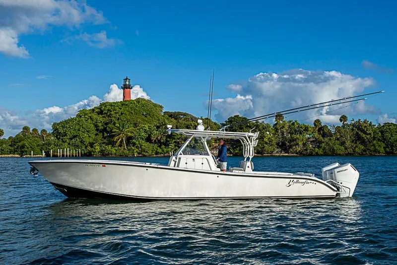 Slide: The Image of 2011 Yellowfin 39 Offshore boat on water near lush island and lighthouse. - 37