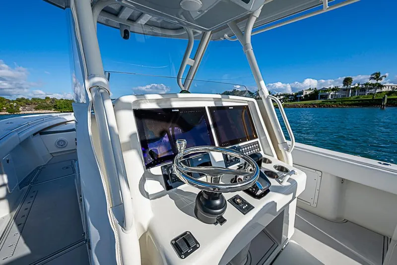 Slide: The Image of 2011 Yellowfin 39 Offshore boat helm with dual screens and steering wheel on open water. - 17